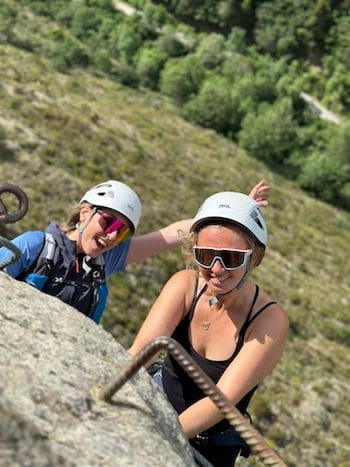 Deux copines souriantes en haut de la via ferrata de Llo dans le 66 avec un guide de haute montagne