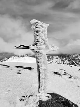 La croix au sommet du Mortiers à 2605 mètres, couverte de congères de neige gelée.