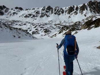 Randonneur à ski lors d'un raid en Andorre, partant de Grandvalira-Grau Roig, encadré par un guide de haute montagne, longeant un lac gelé dans les Pyrénées andorranes, face à d'imposants sommets enneigés. Randonneur à ski lors d'un raid en Andorre, partant de Grandvalira-Grau Roig, encadré par un guide de haute montagne, longeant un lac gelé dans les Pyrénées andorranes, face à d'imposants sommets enneigés.